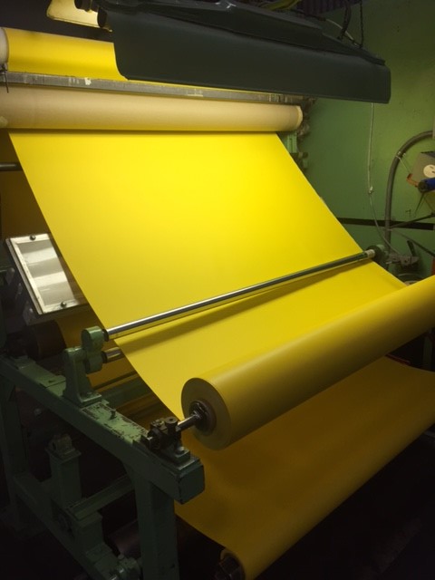 Yellow general purpose industrial vinyl fabric on a rolling machine